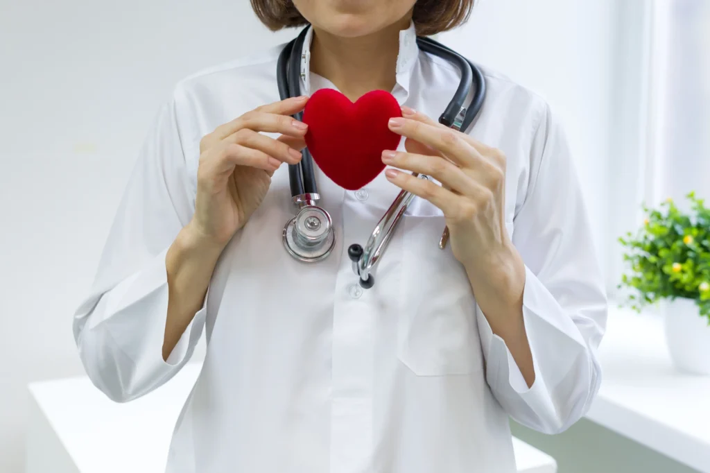 Doctor holding a red heart model symbolising heart health and prevention of heart disease
