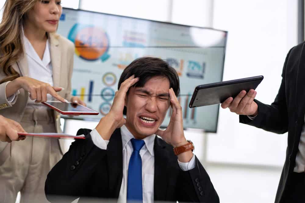 Stressed office worker overwhelmed by pressure, highlighting how stress affects heart health according to heart doctors in Singapore.