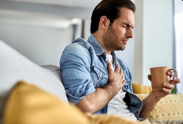 Seorang pria sedang memegangi dadanya akibat gejala serangan jantung