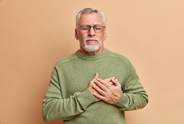 Seorang pria sedang memegang dada karena sakit jantung