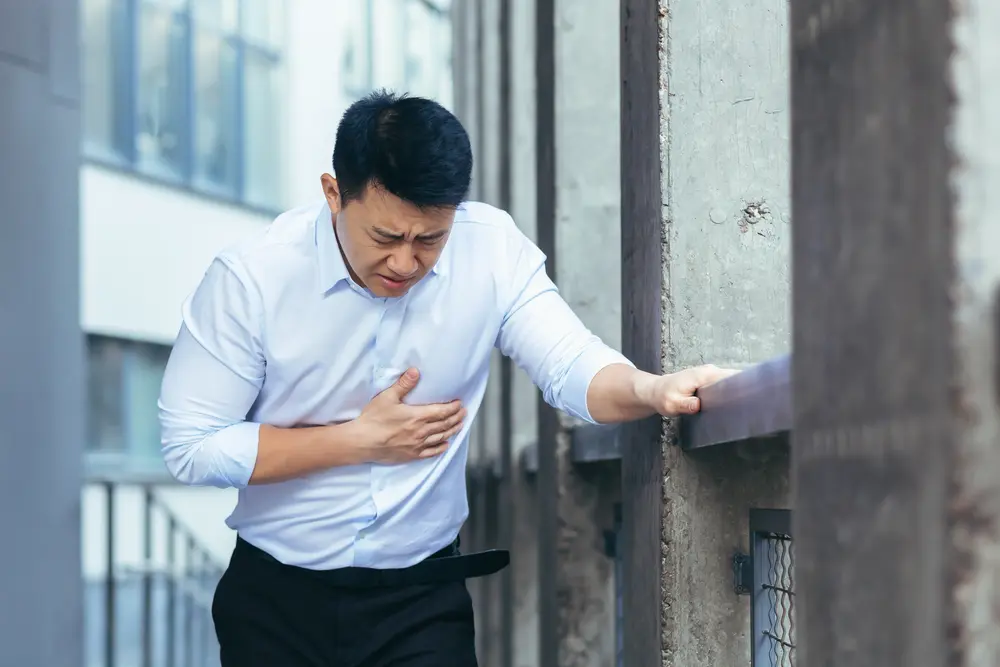 Man experiencing chest pain outdoors, possible cardiac arrest symptoms in diabetic patients