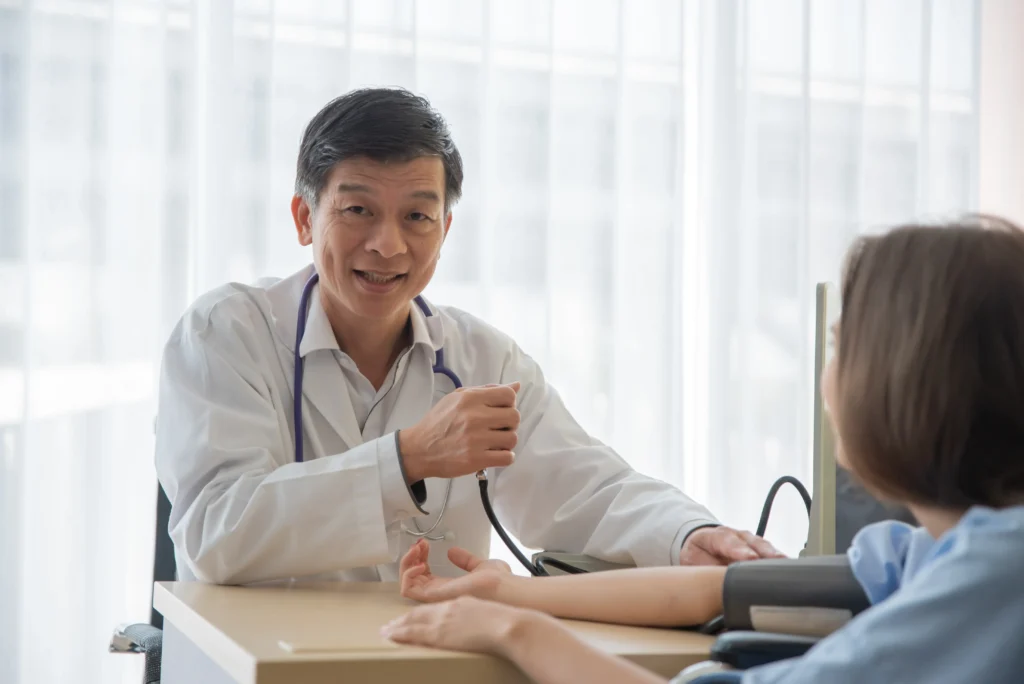 Cardiologist consulting patient and checking blood pressure during heart health assessment