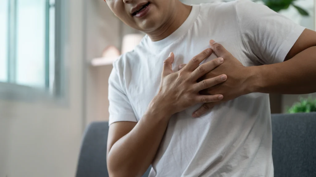 Person experiencing chest pain, a common symptom of heart artery blockage and coronary artery disease