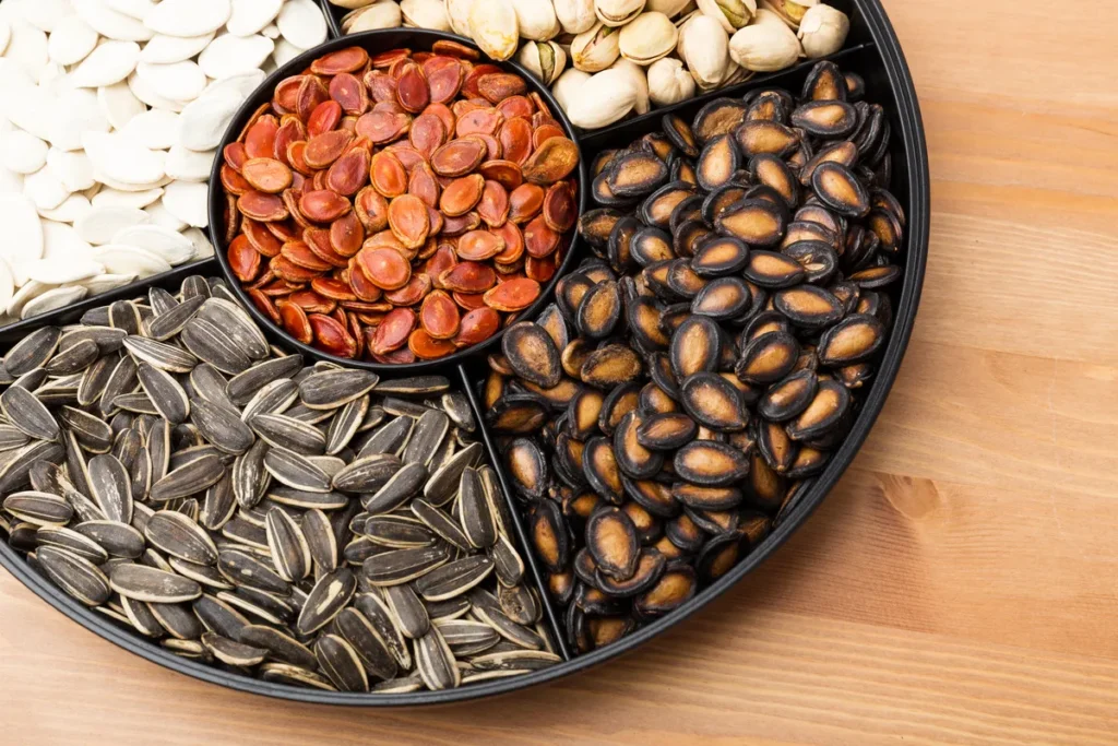 Assorted nuts and seeds including sunflower seeds, pumpkin seeds, and pistachios for heart-healthy fats and cholesterol support