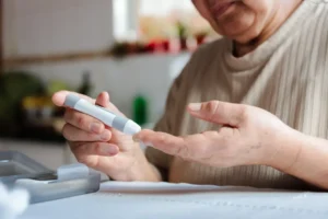 Person checking blood sugar with a glucose monitor, managing diabetes and heart disease risk