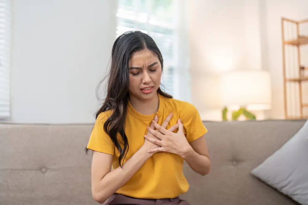 Young woman experiencing chest pain, possible heart disease symptoms in women
