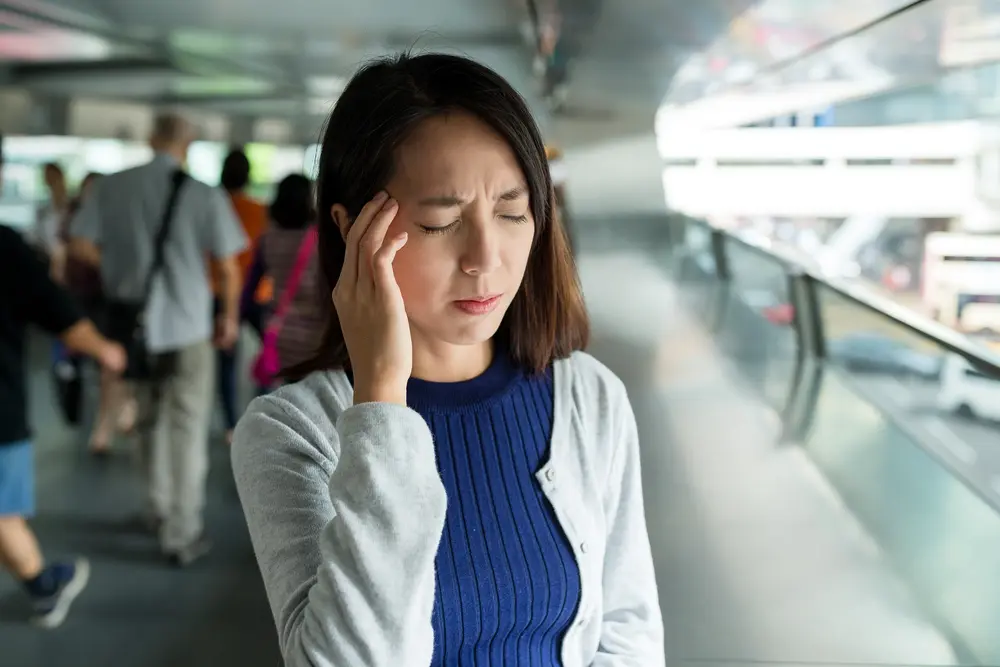 Woman feeling dizzy in hot weather, possible high blood pressure symptoms